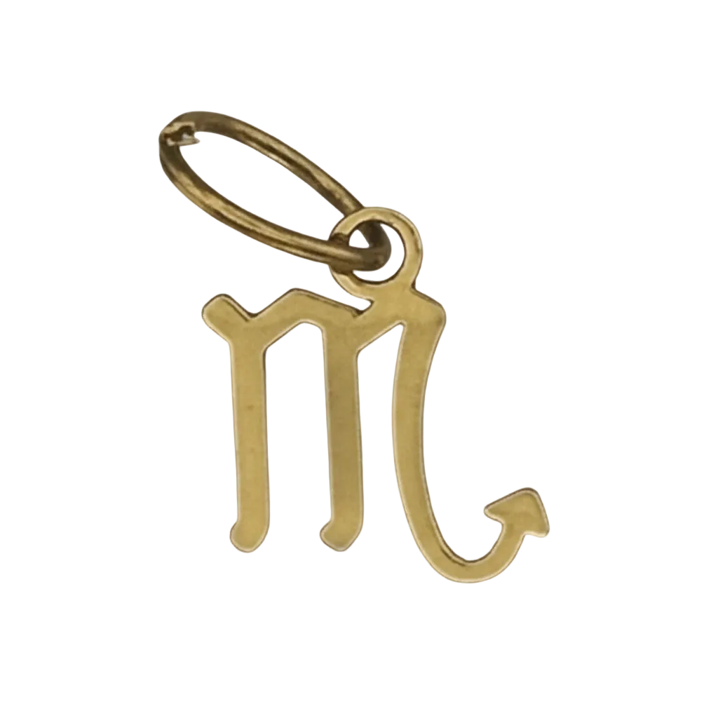 close-up of gold-tone scorpio zodiac symbol charm on black background