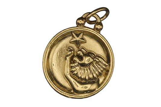 close-up of round gold charm with clown reaching for a star