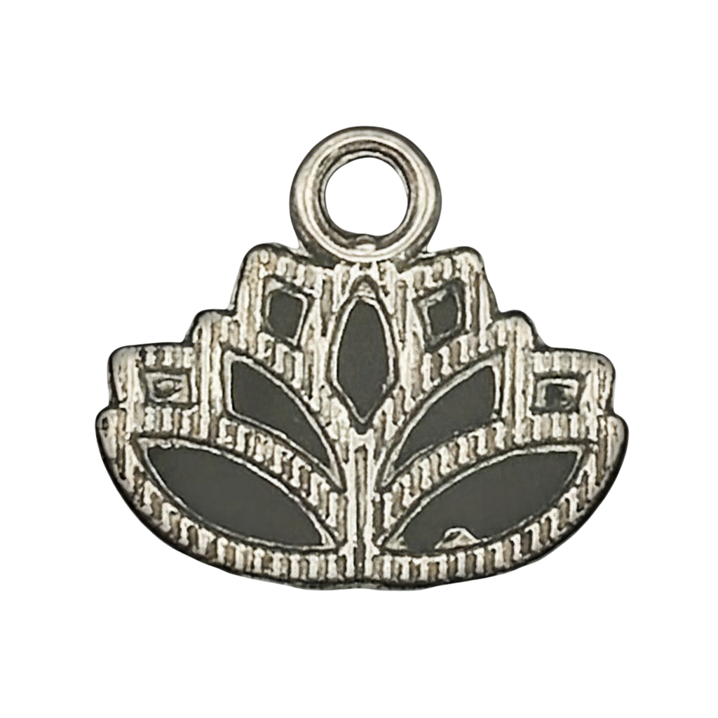 close-up of a small silver lotus flower charm with etched details on a black background