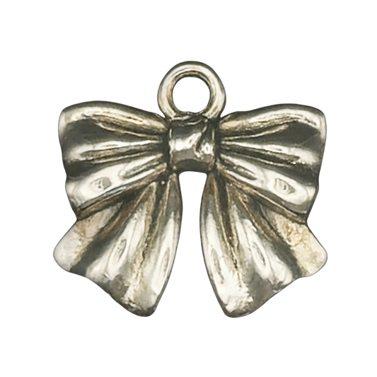 close-up of a silver-tone bow charm on a black background