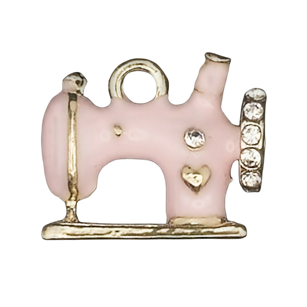 close-up of pink enamel sewing machine charm with gold-tone edges and rhinestones