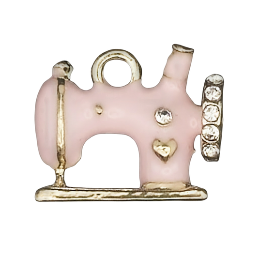 close-up of pink enamel sewing machine charm with gold-tone edges and rhinestones