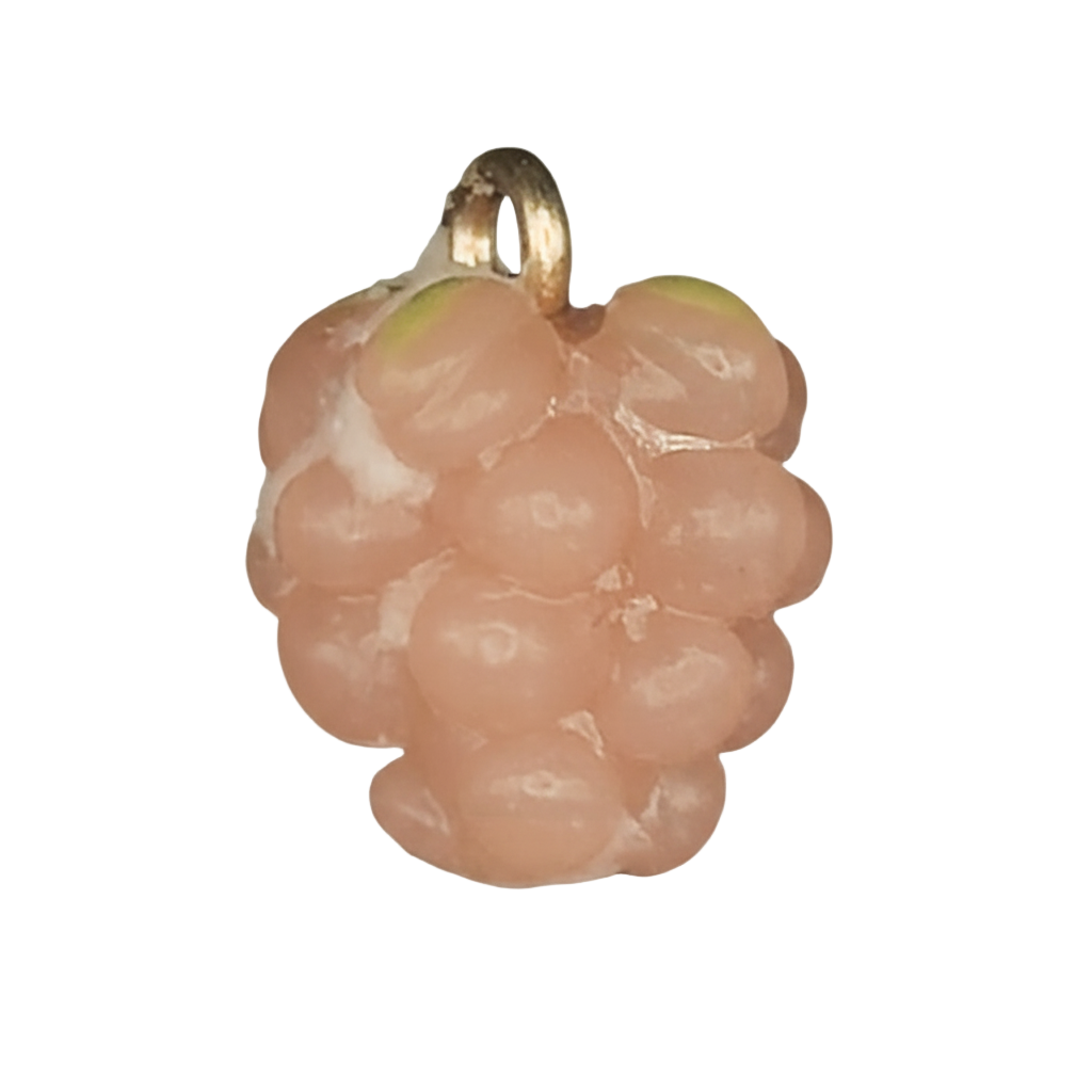 close-up of a small pink raspberry-shaped charm with a gold-tone top on a black background