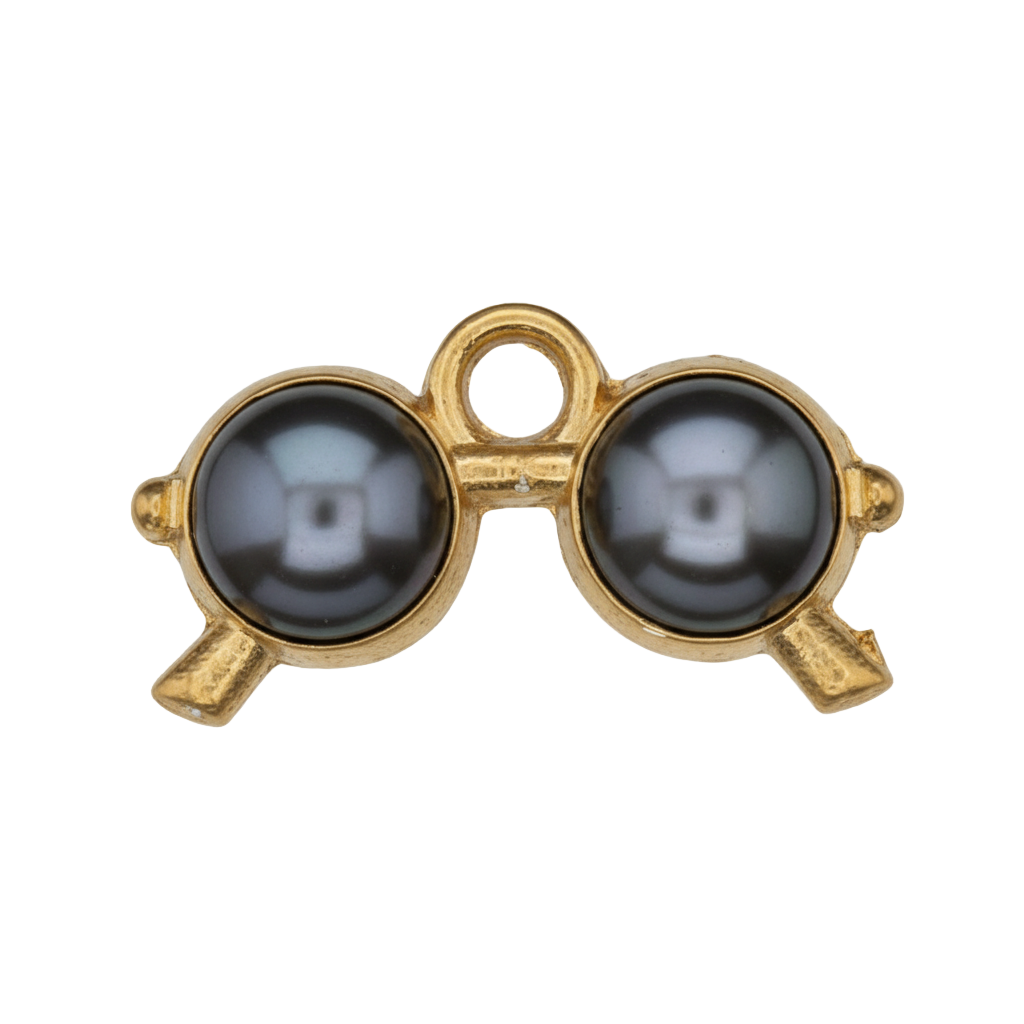 close-up of gold-tone binoculars charm with black enamel on a black background