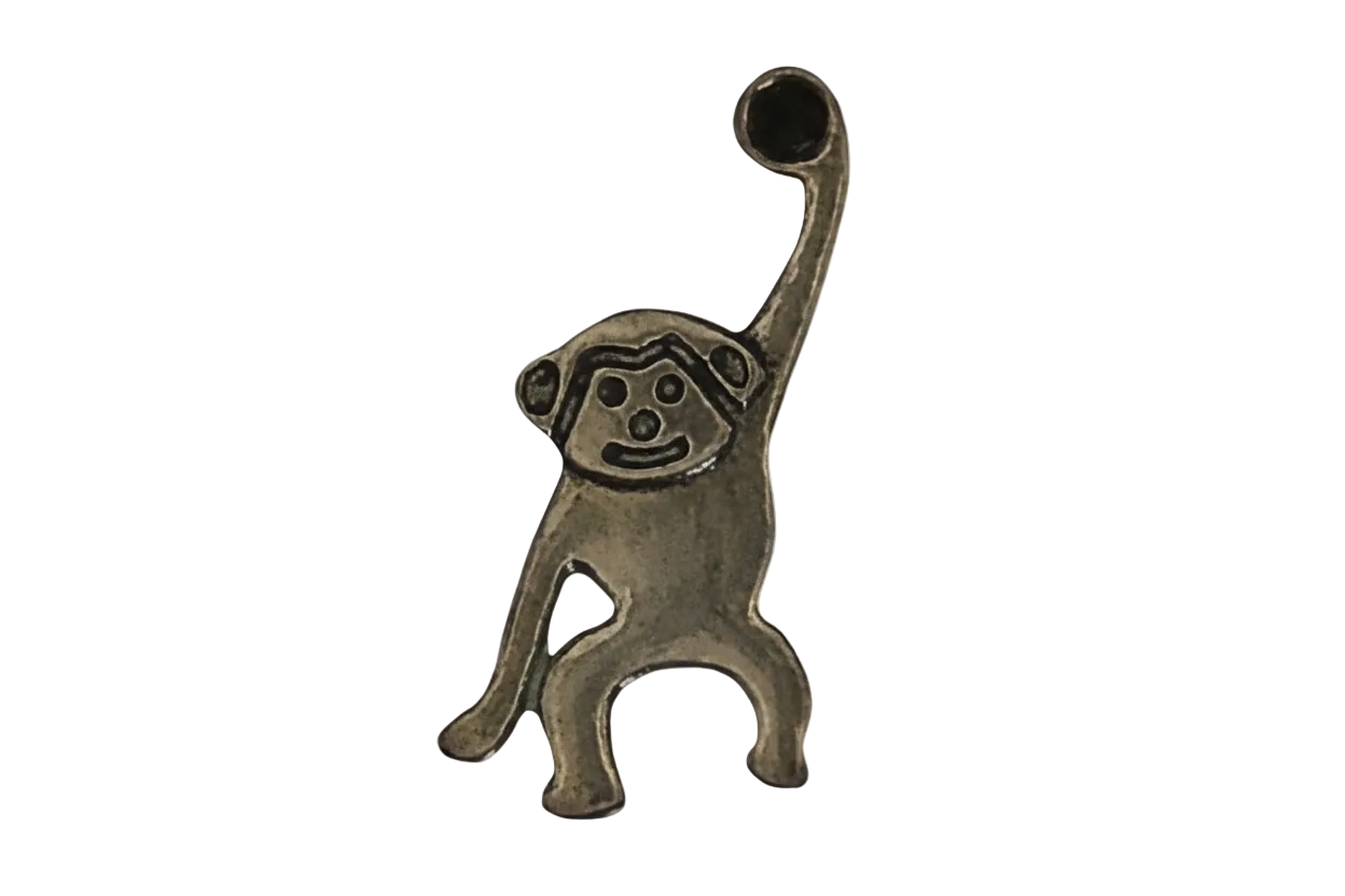 close-up bronze monkey charm with one arm raised on black background