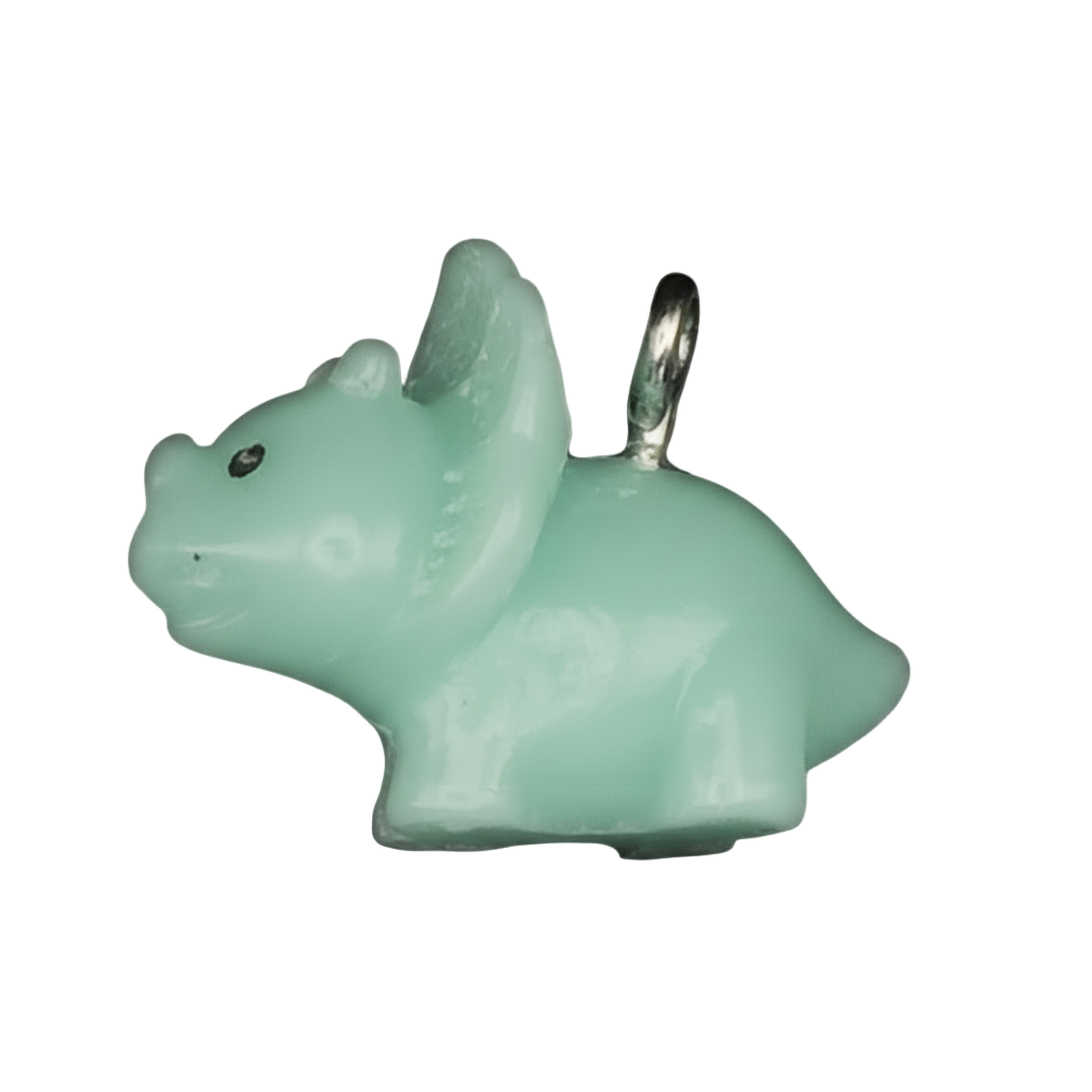 close-up of a mint green triceratops charm on a black background