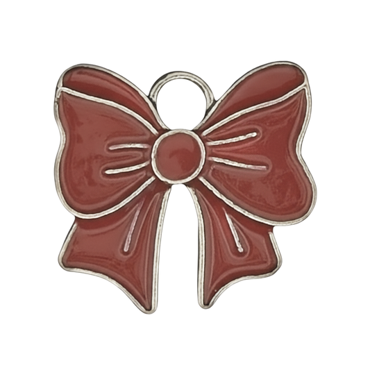 close-up of a red enamel bow charm with silver outline on black background