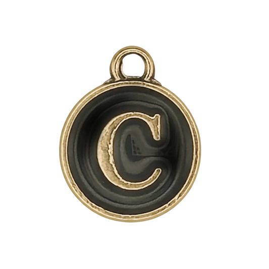 close-up of round black and gold letter C charm