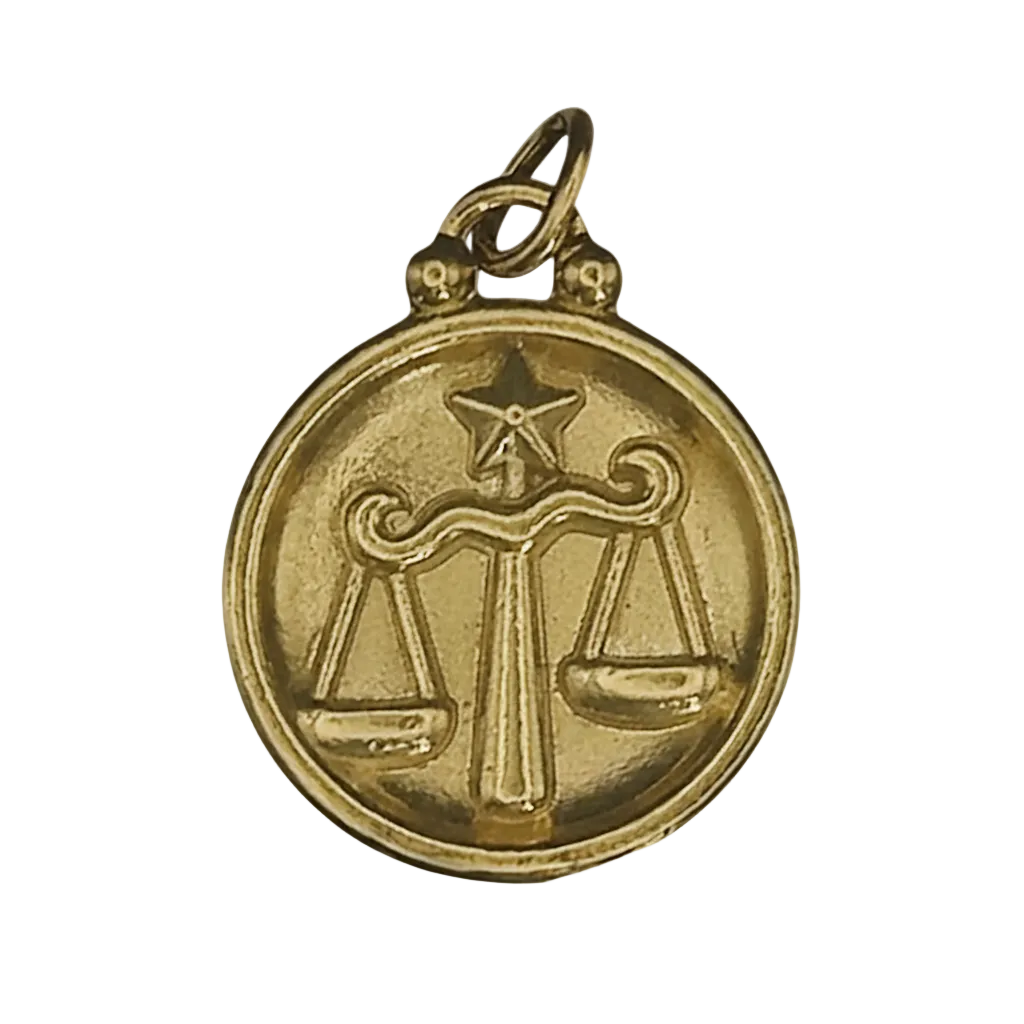 close-up of gold round charm with Libra scales and star