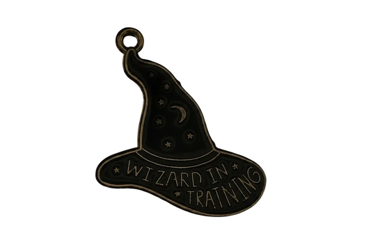 close-up of antique gold wizard hat charm with moon, stars, and the words "WIZARD IN TRAINING"