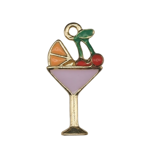Close-up of enamel cocktail glass charm with purple drink, orange slice, cherries, and green straw on gold-tone outline.