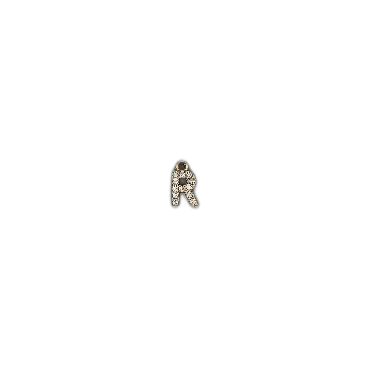 small gold-tone letter R charm with clear crystals on a black background