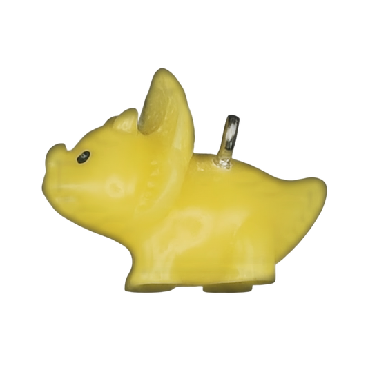 close-up of a small yellow dog-shaped charm on a black background