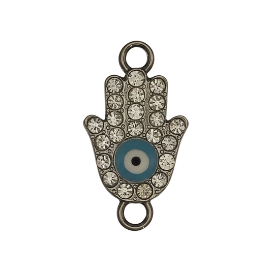 close-up of silver-tone hamsa hand charm with clear rhinestones and blue evil eye center on black background