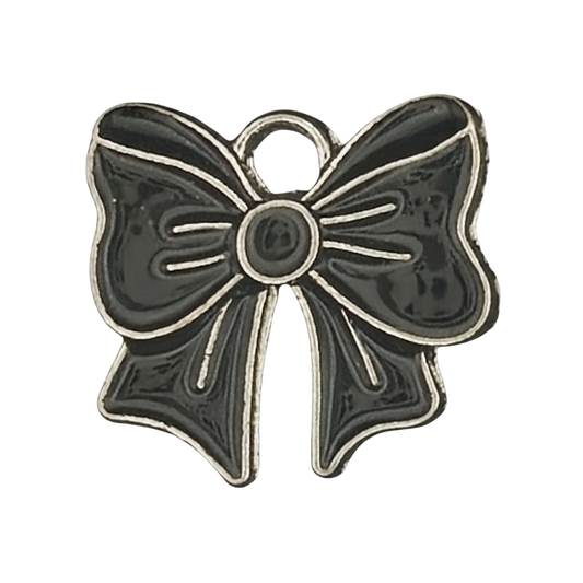close-up of a small black enamel bow charm with silver outline on a black background