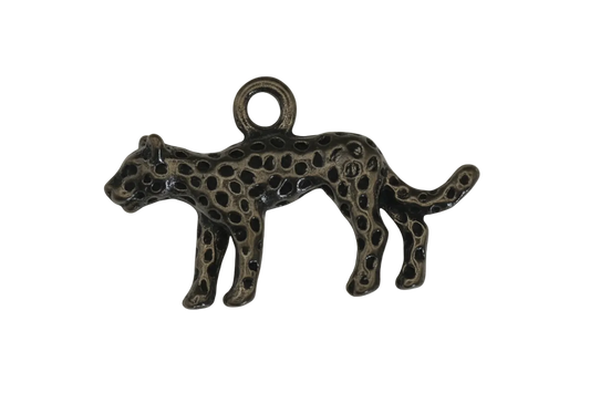 close-up of a small metal leopard charm with raised spots on a black background