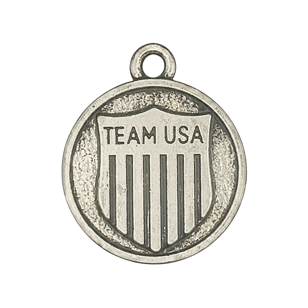 close-up of round silver charm with 'TEAM USA' shield design