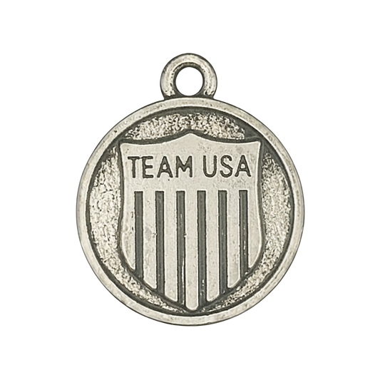 close-up of round silver charm with 'TEAM USA' shield design