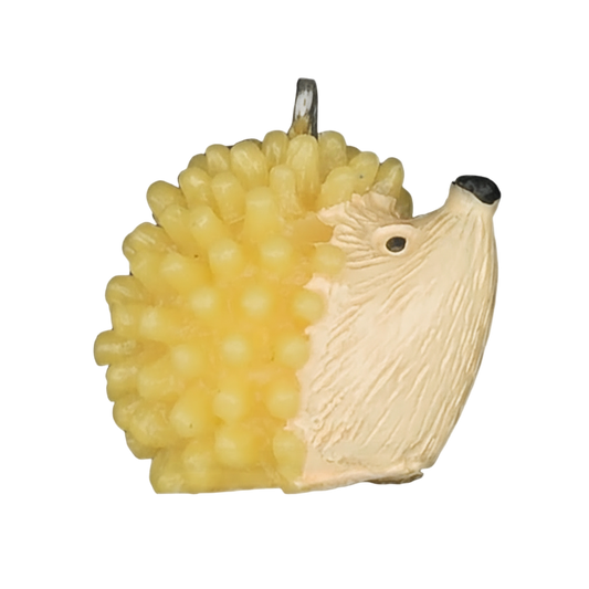 close-up of yellow and cream hedgehog charm on black background