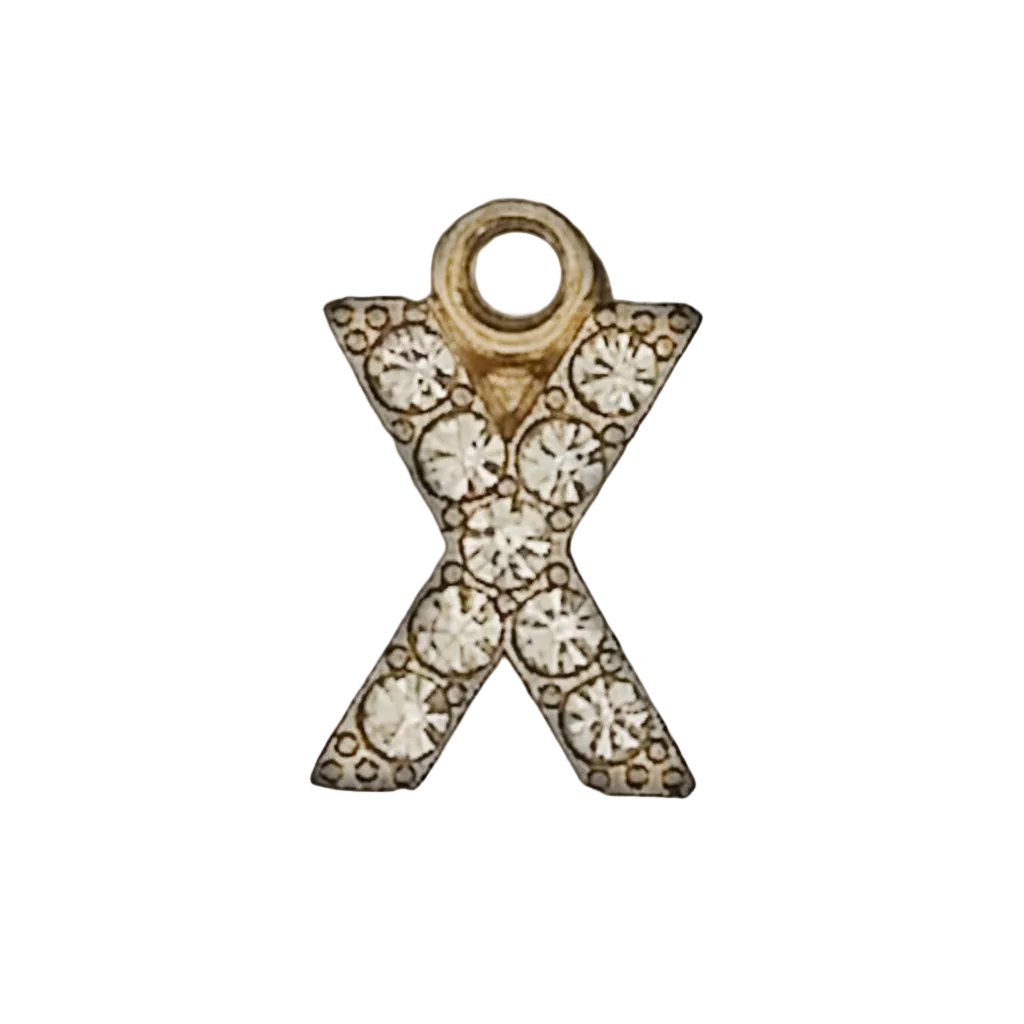 close-up of a gold-tone letter X charm with clear crystals on a black background