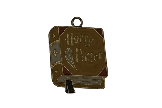 Enamel book-shaped charm with quill and 'Harry Potter' text on a black background.