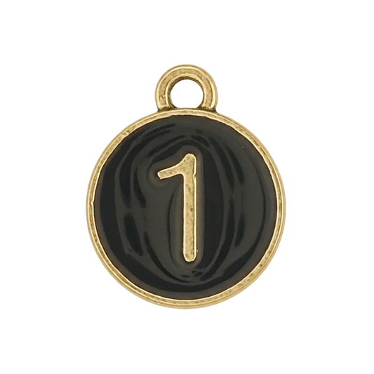 Close-up of a small round black charm with a gold number 1 and border.