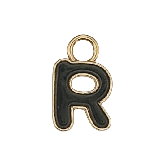 Close-up of a black enamel letter R charm with a gold outline on a black background.