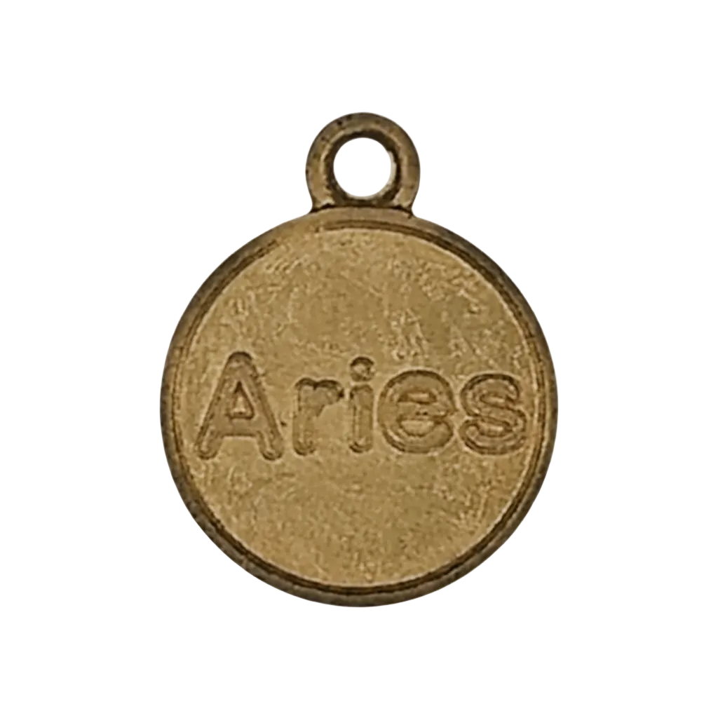 close-up of round gold-tone charm engraved with the word Aries on a black background