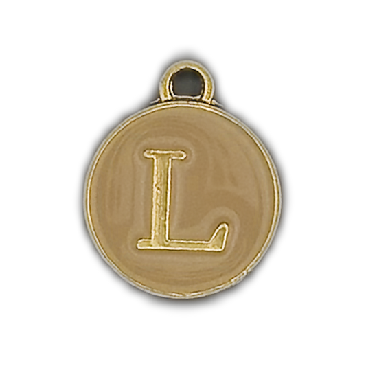 close-up of round disc charm with gold letter L on beige background