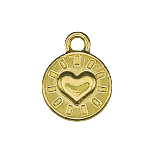 close-up of a small gold-tone round charm with a raised heart and radiating marks on a black background