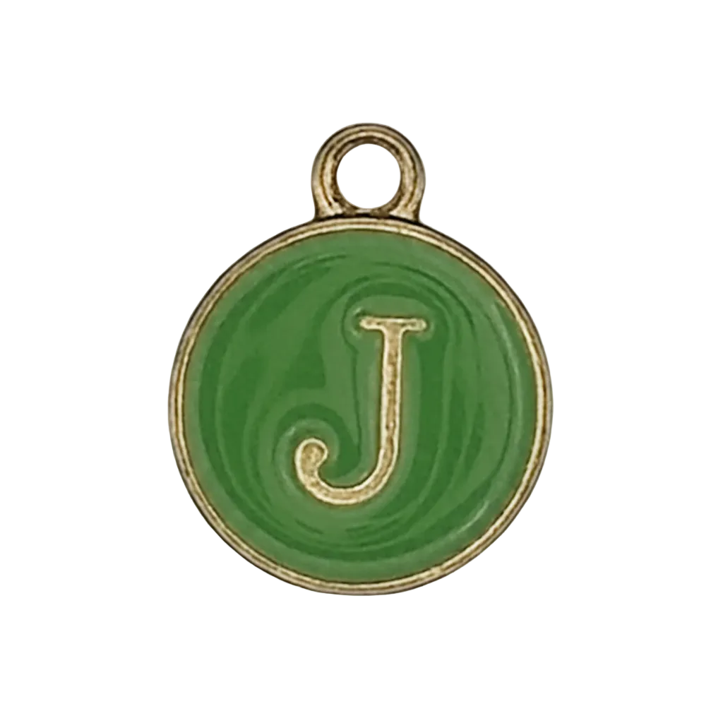 Close-up of a small round green charm with a gold letter J and rim on a black background.