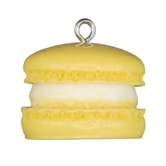close-up of a yellow macaron charm with white filling on a black background