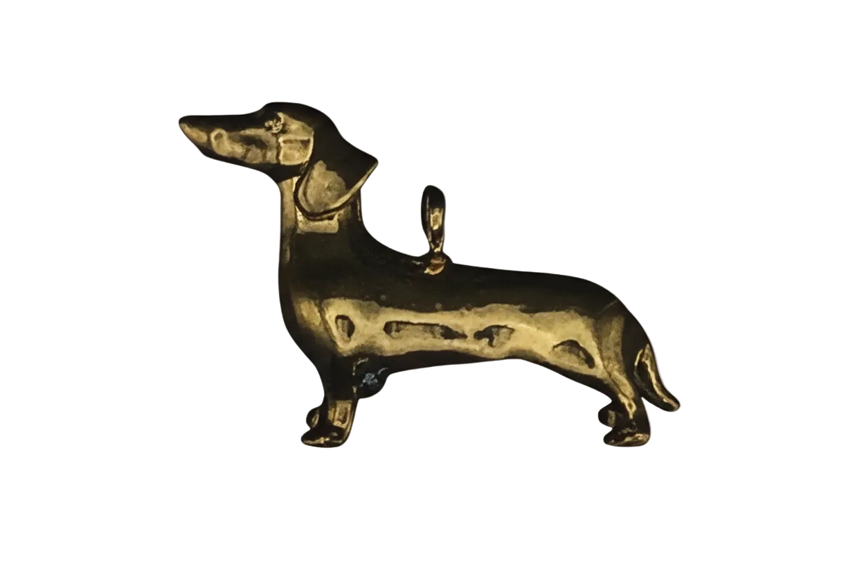 gold dachshund dog charm on black background