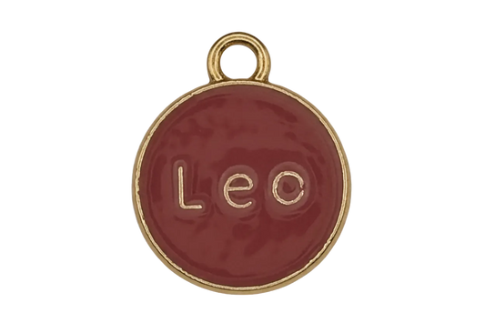 close-up of red round 'Leo' enamel charm with gold rim and loop on a black background