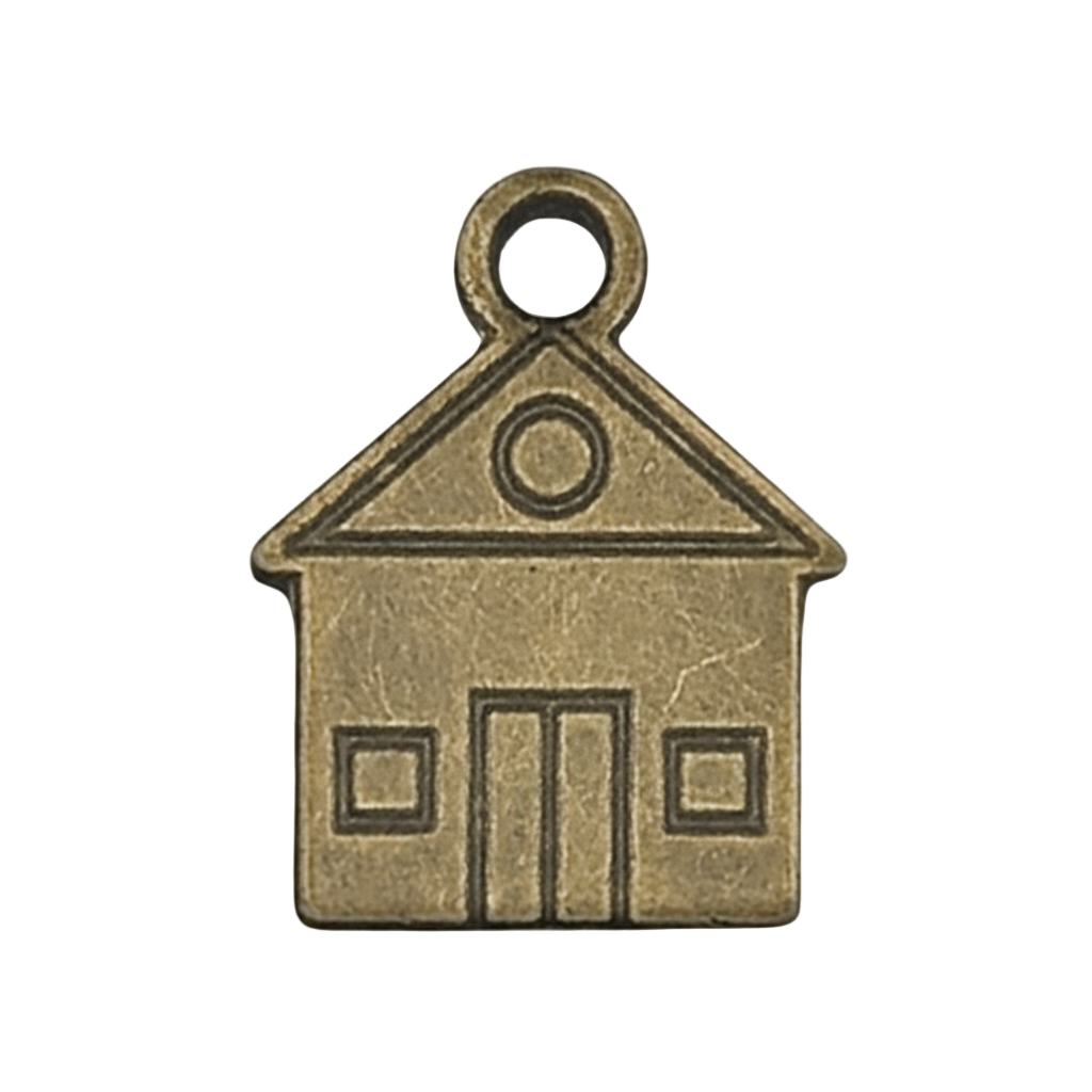 close-up of a small antique brass house-shaped charm