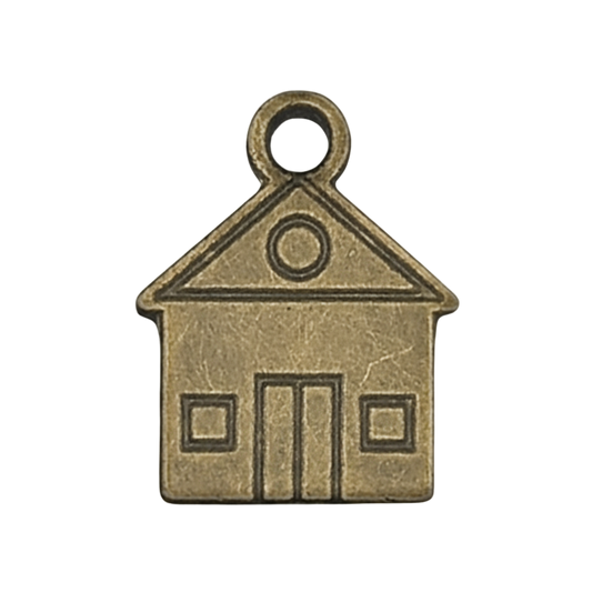 close-up of a small antique brass house-shaped charm