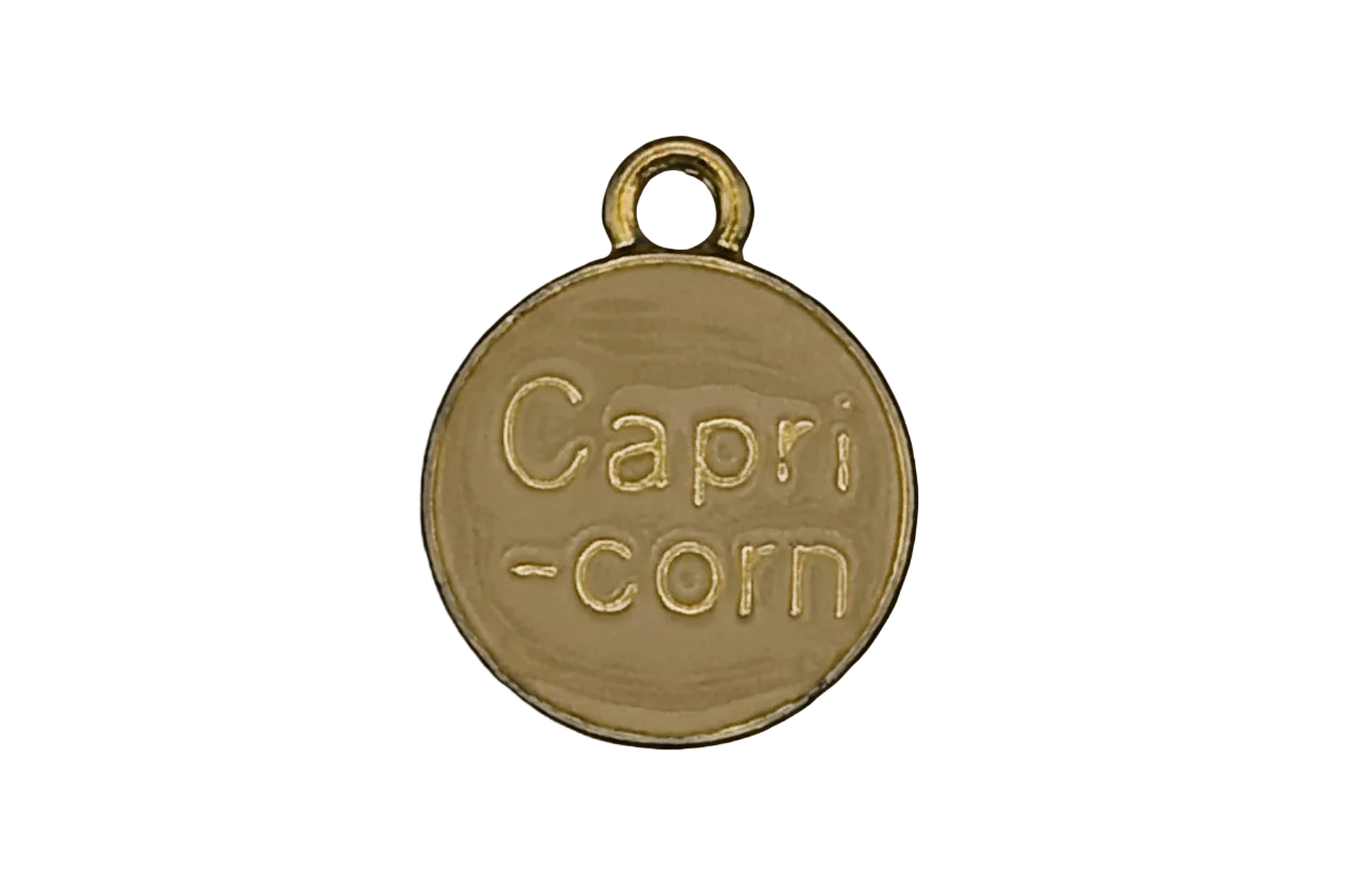 close-up of gold round charm engraved 'Capri-corn'