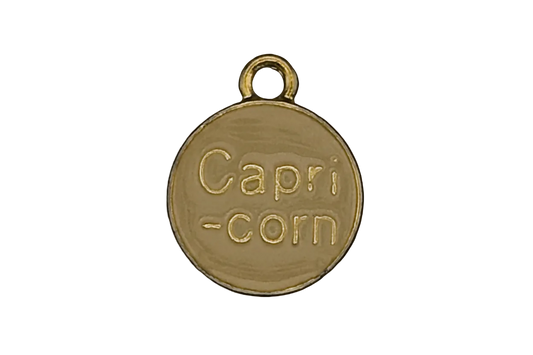 close-up of gold round charm engraved 'Capri-corn'