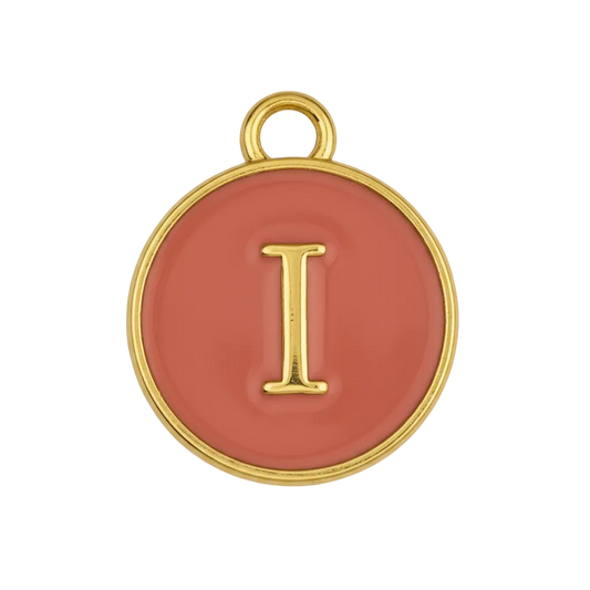 close-up of round red enamel charm with gold letter I