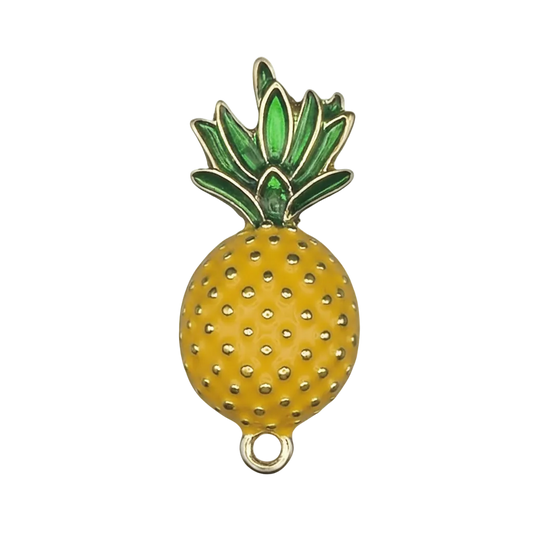 close-up of yellow and green enamel pineapple charm on black background
