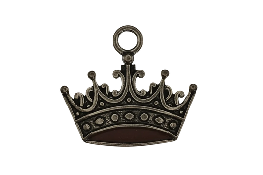 close-up of antique gold crown charm on black background