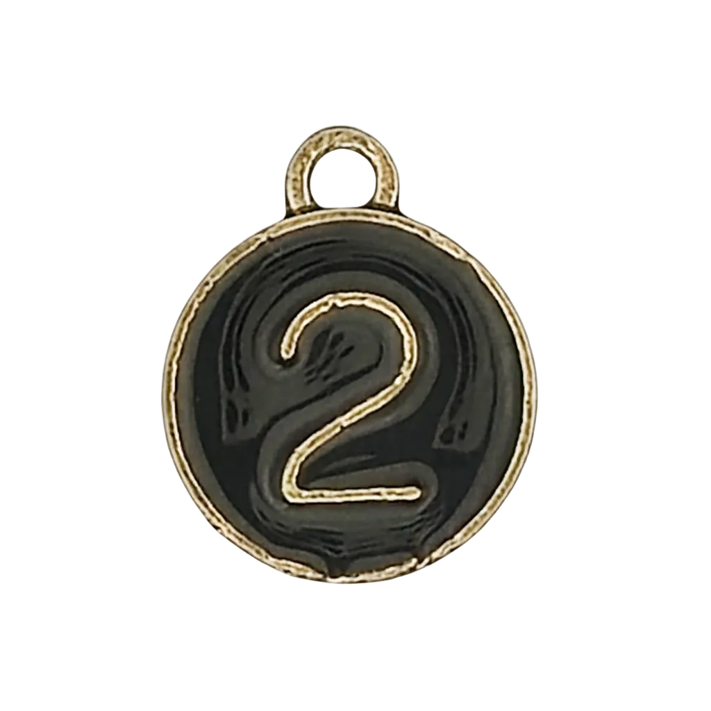 close-up of a round black charm with a gold number 2