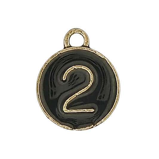 close-up of a round black charm with a gold number 2