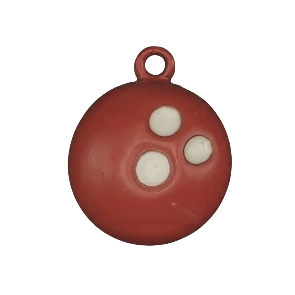 Close-up of red bowling ball charm with three white finger holes.