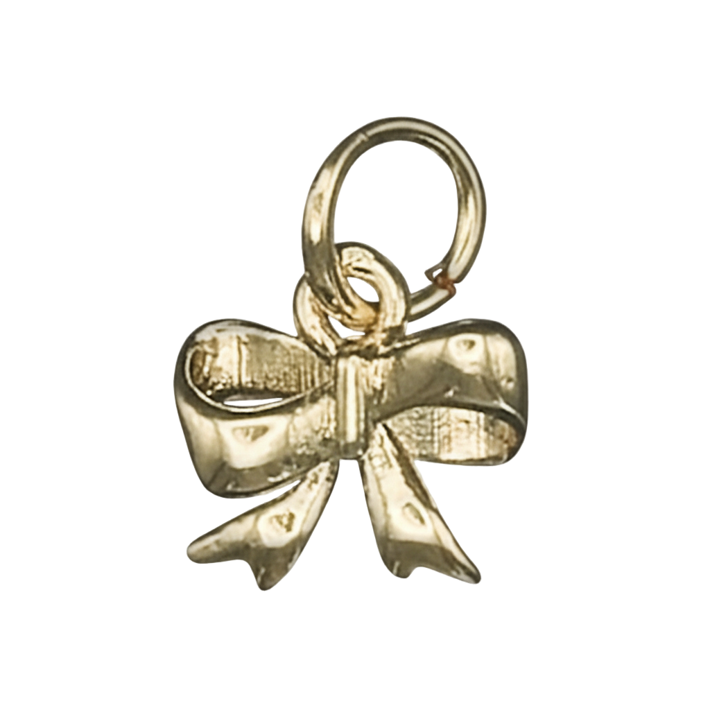 close-up of a small gold bow charm on a black background