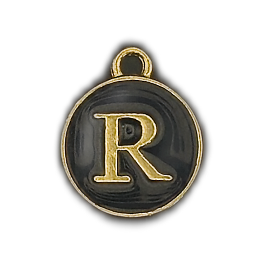 close-up of round black charm with gold letter R