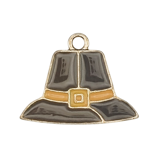 close-up of black and gold enamel pilgrim hat charm on a black background