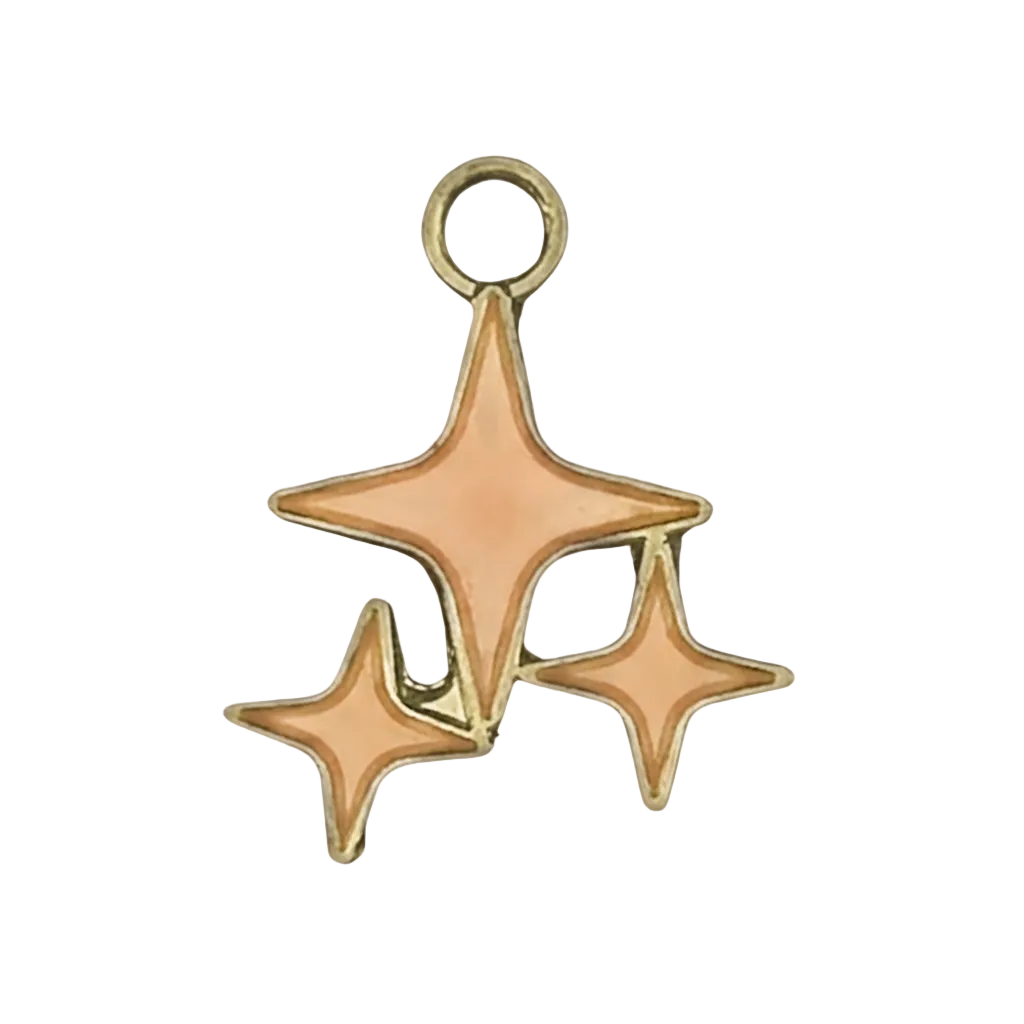 close-up of a gold-tone charm with three peach enamel starbursts on a black background
