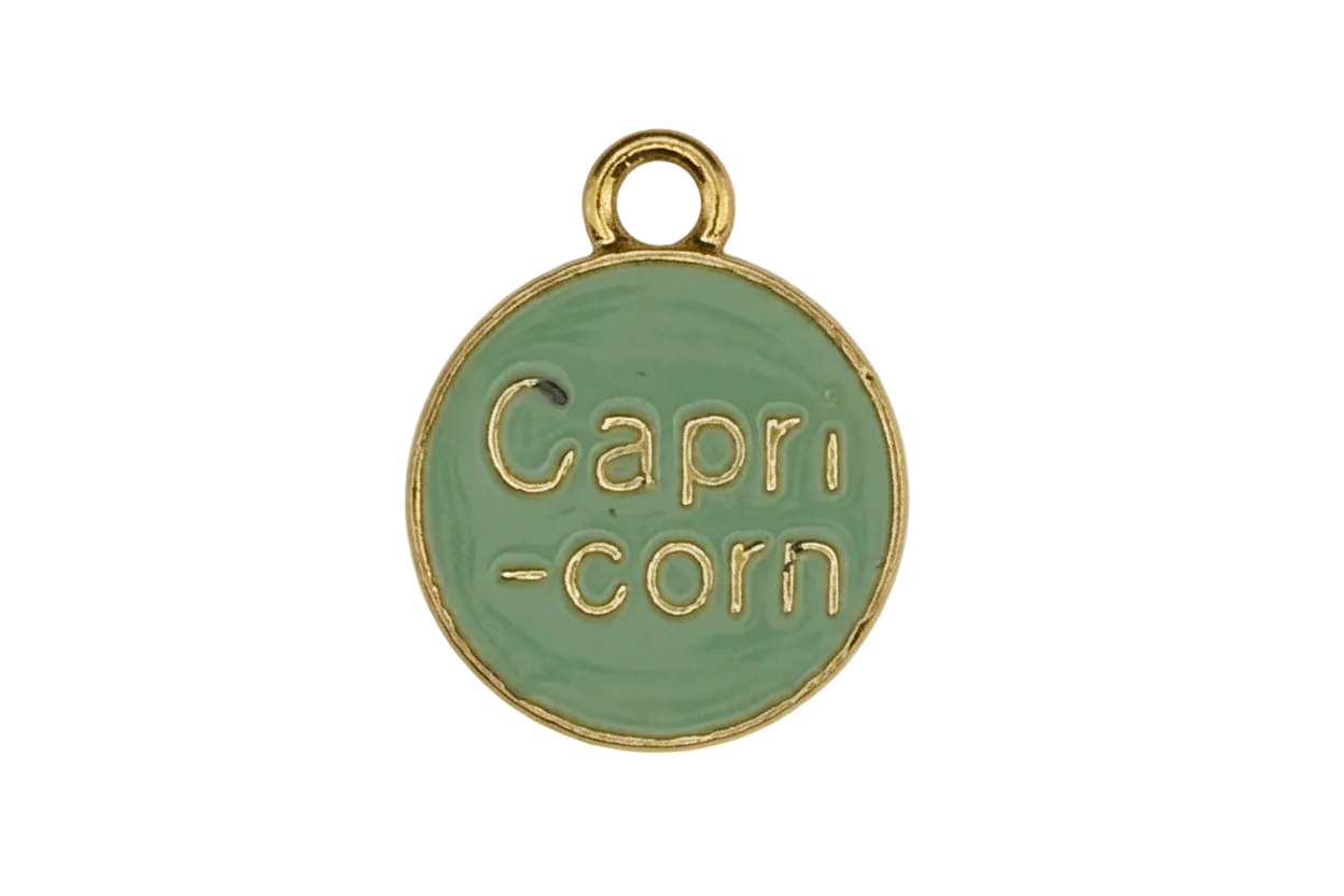close-up of green round charm reading 'Capri-corn' with gold edges