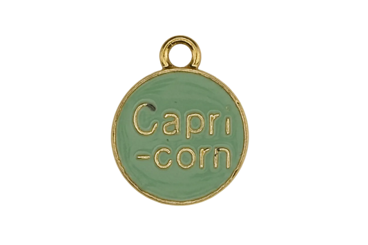 close-up of green round charm reading 'Capri-corn' with gold edges